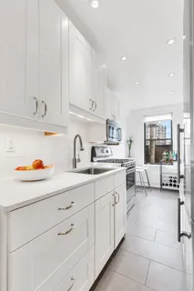 a kitchen with cabinets a sink and white appliances