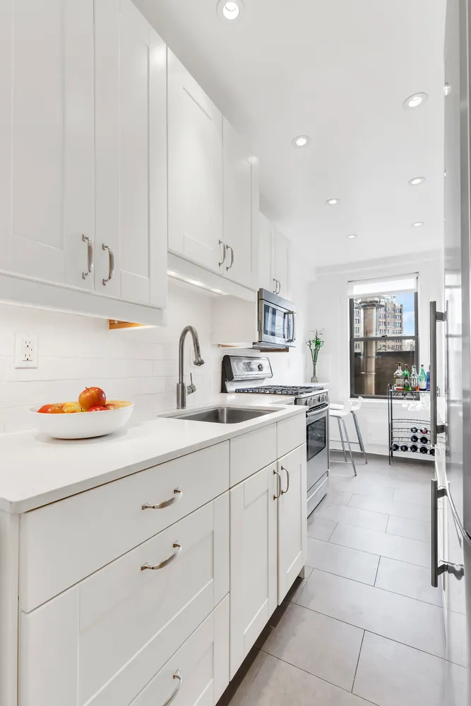 a kitchen with cabinets a sink and white appliances