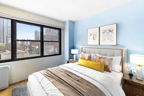 a bedroom with a bed and a large window