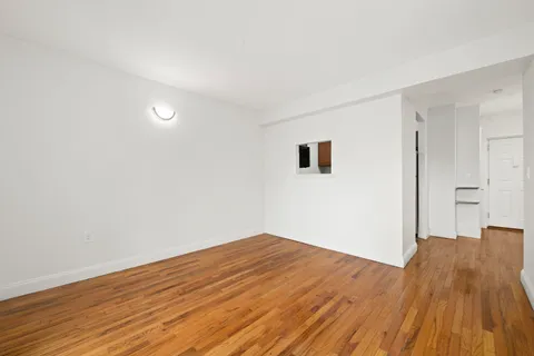 a view of a room with wooden floor and white walls