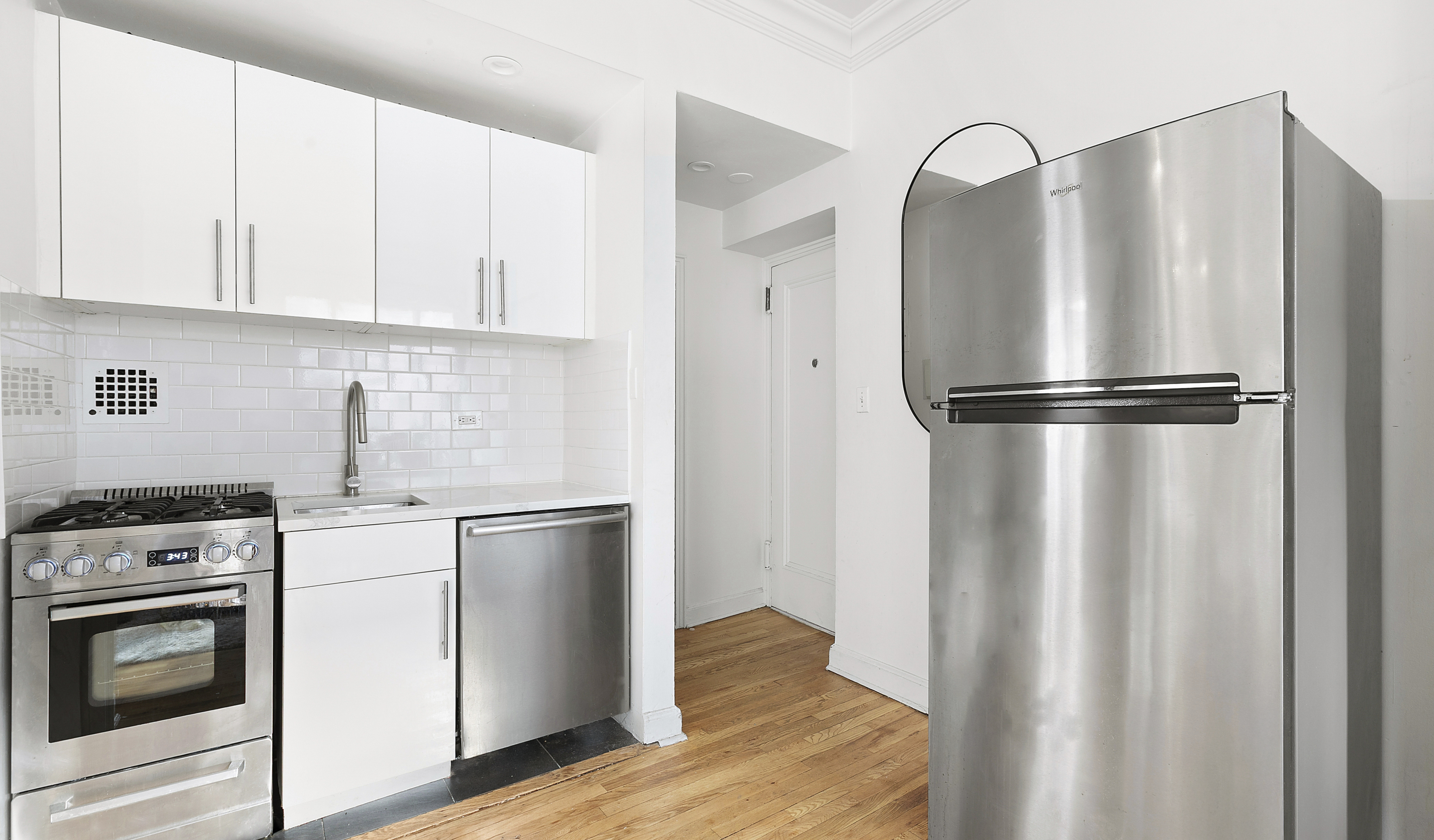 32 Downing Street, Unit 3D Manhattan, NY 10014 - Photo 2 of 4 a kitchen with stainless steel appliances a refrigerator and a stove top oven