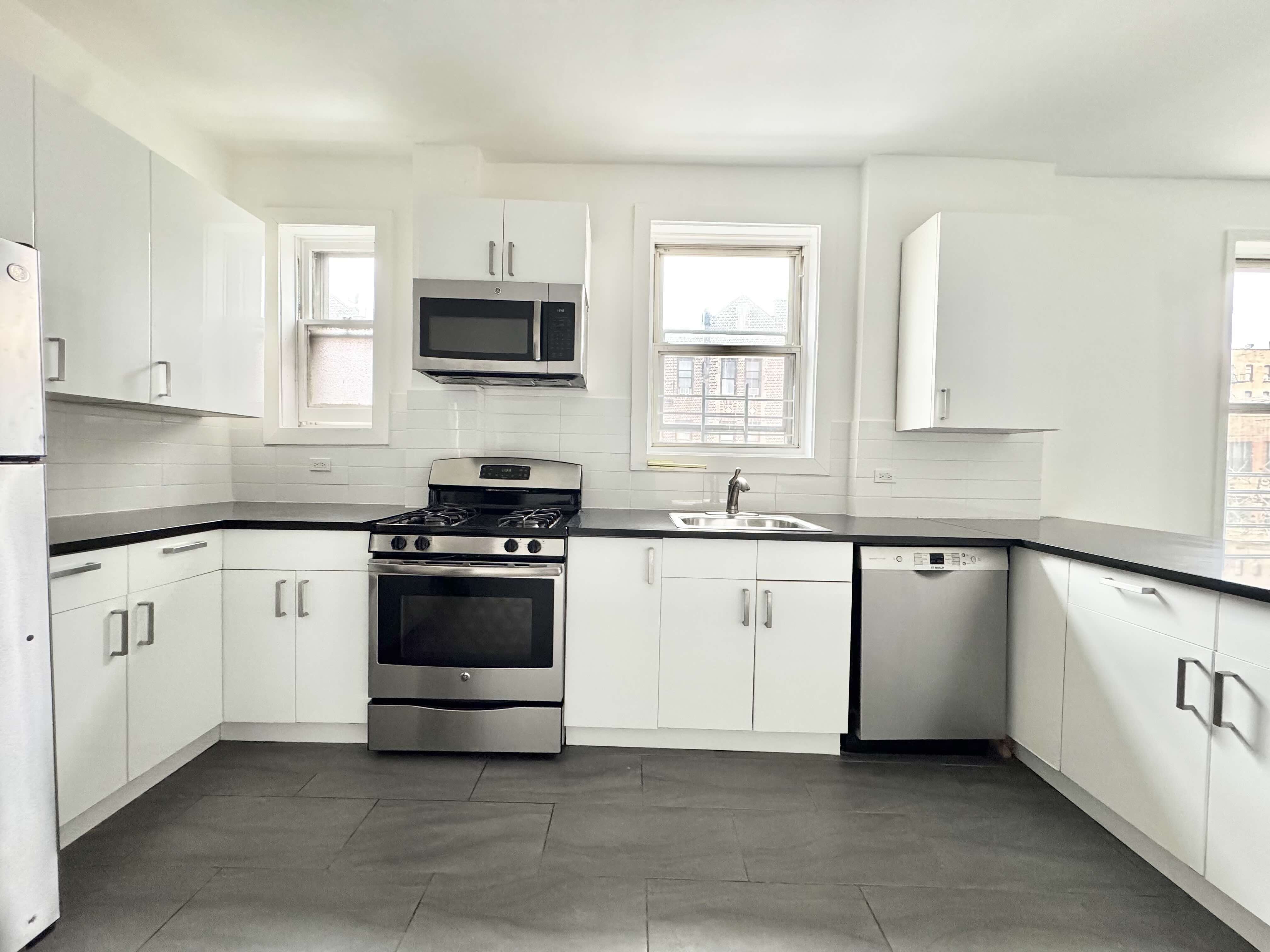 406 Rogers Avenue, Unit 3 Brooklyn, NY 11225 - Photo 2 of 9 a kitchen with granite countertop white cabinets and stainless steel appliances