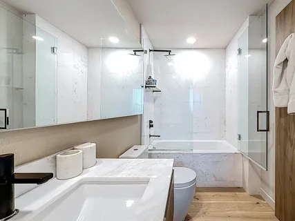 a bathroom with a double vanity sink mirror and bathtub