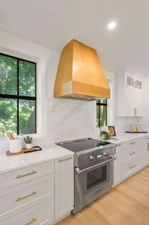 a kitchen with a stove and a white wooden cabinets