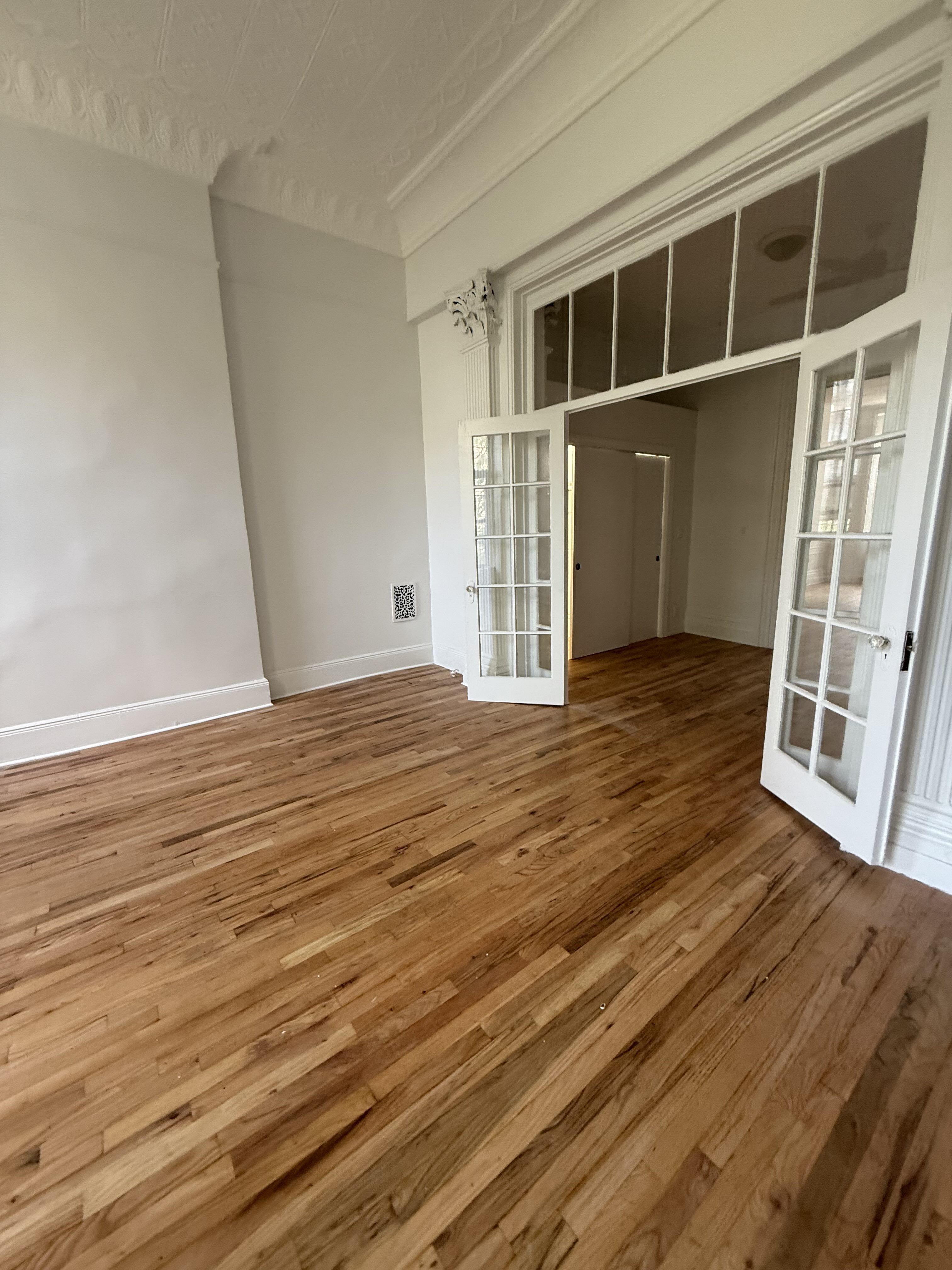 141 Summit Street, Unit 2 Brooklyn, NY 11231 - Photo 4 of 12 a view of an empty room with wooden floor and a window
