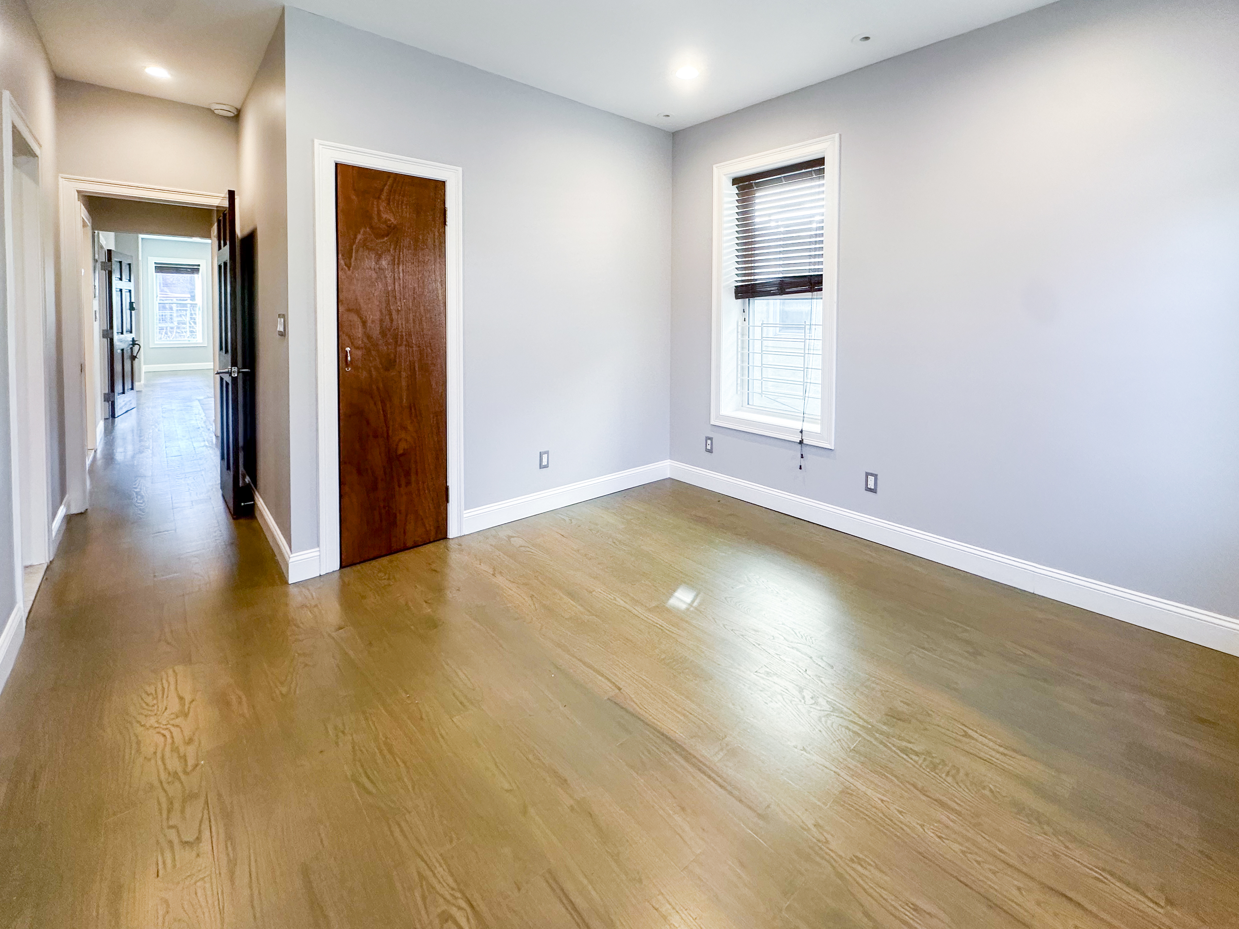 567 New Jersey Avenue, Unit 2 Brooklyn, NY 11207 - Photo 4 of 11 an empty room with wooden floor and windows