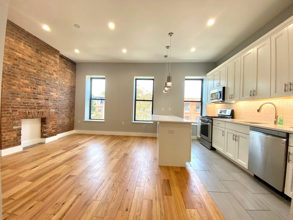 a large kitchen with cabinets wooden floor and a sink