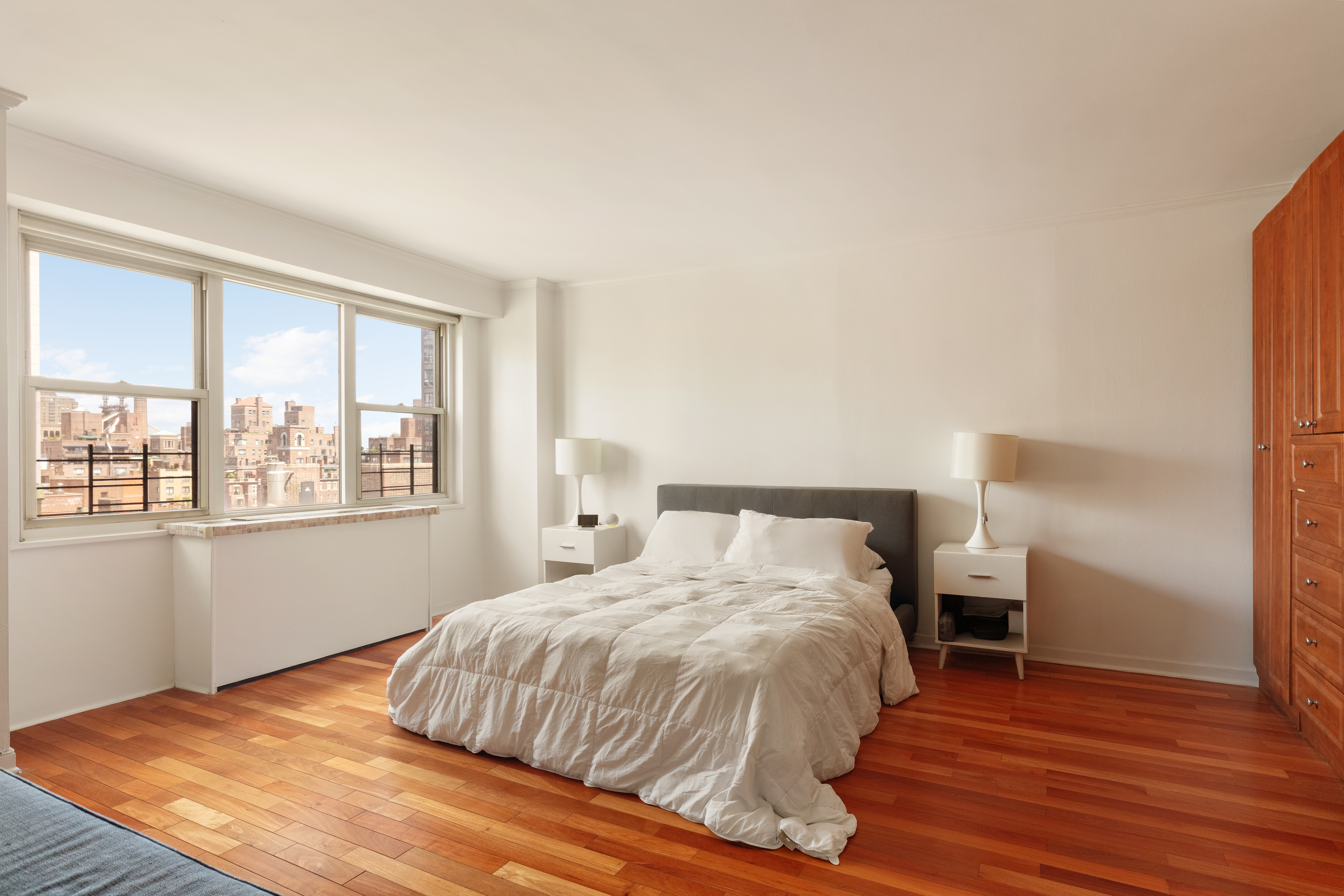 400 East 54th Street, Unit 21CDE Manhattan, NY 10022 - Photo 4 of 10 a bedroom with a bed and wooden floor