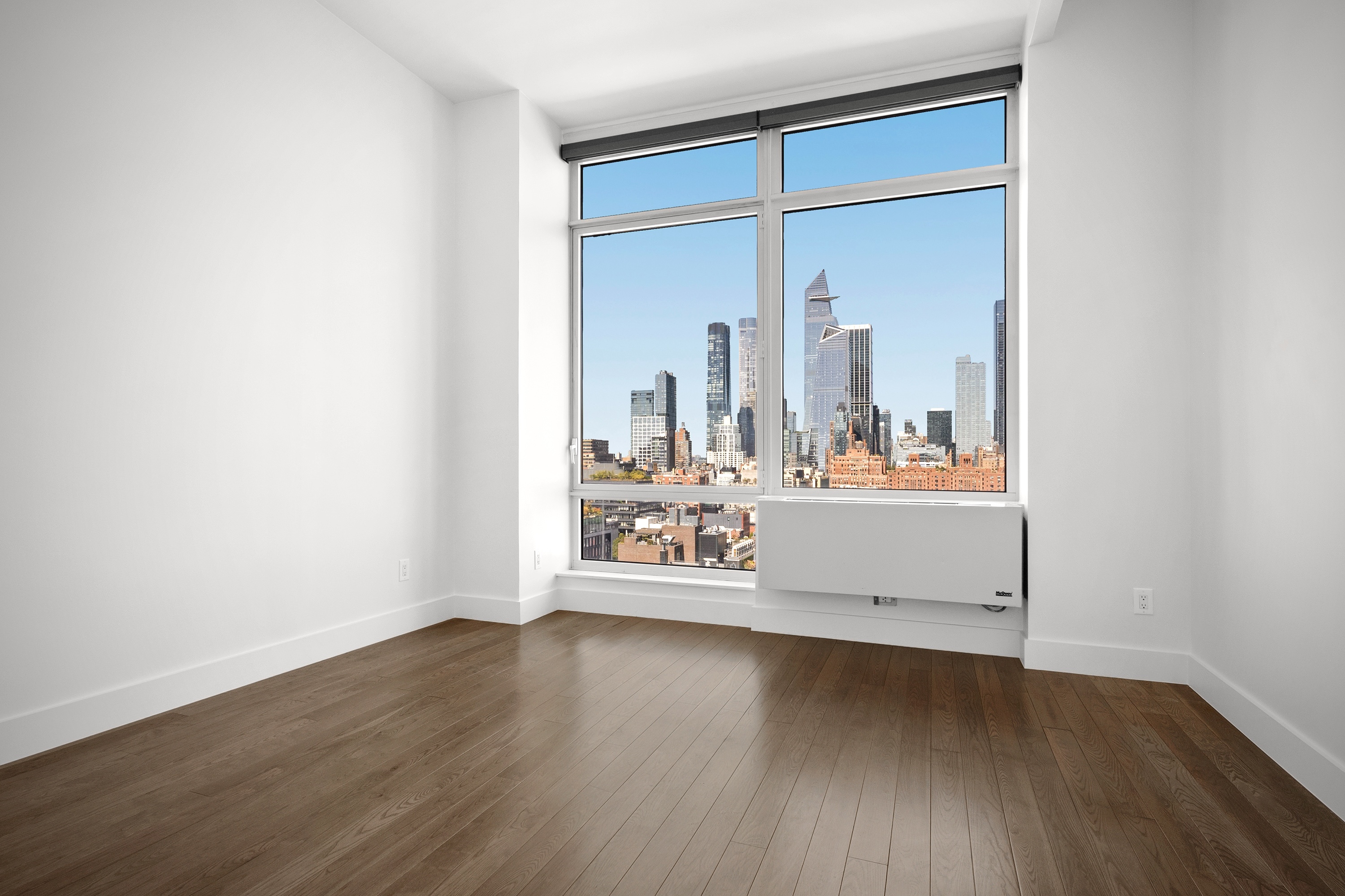 450 West 17th Street, Unit 2003 Manhattan, NY 10011 - Photo 5 of 7 an empty room with wooden floor and a large window