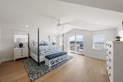 a spacious bedroom with a bed a mirror and a flat screen tv