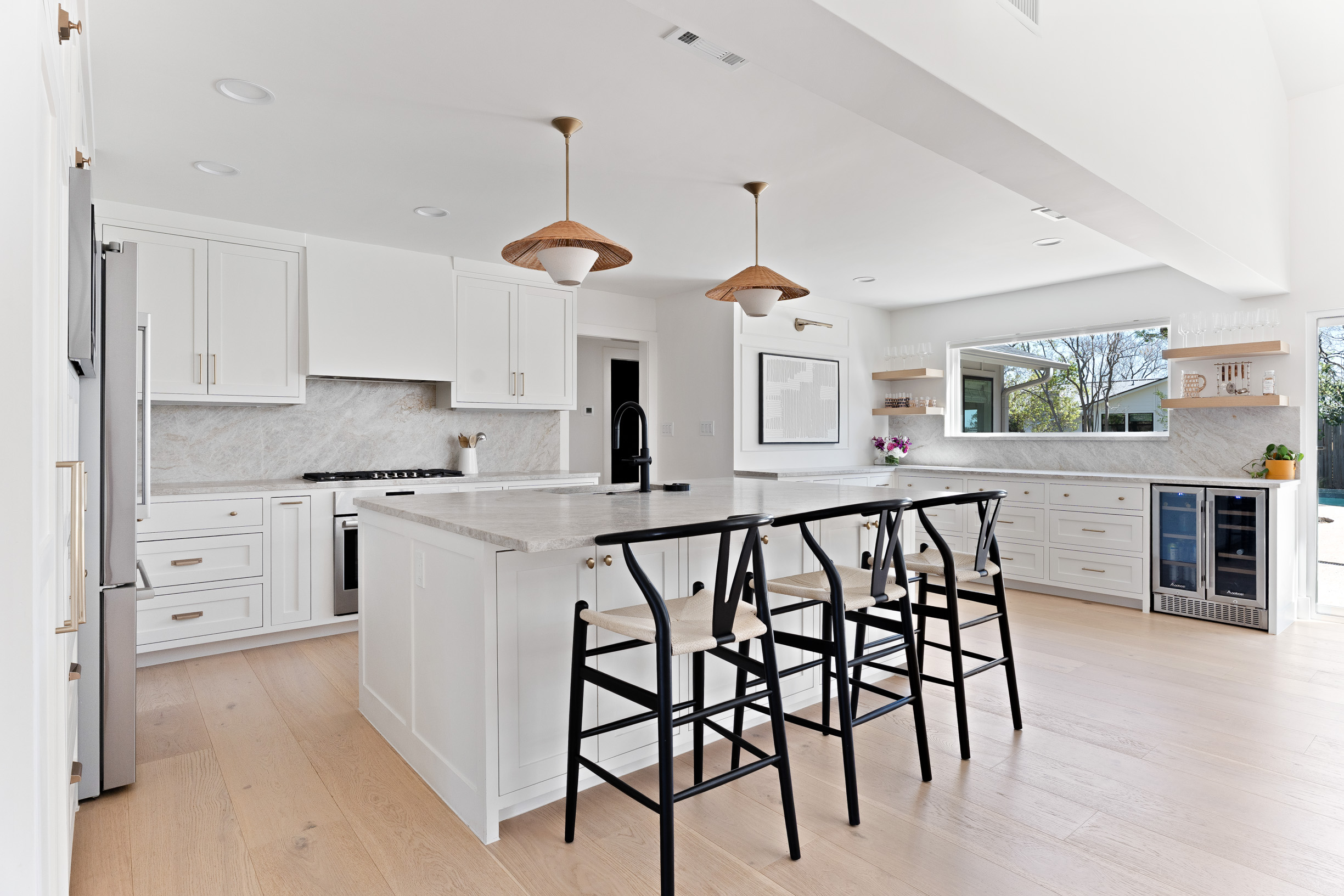 a kitchen with stainless steel appliances kitchen island granite countertop a table chairs and a refrigerator