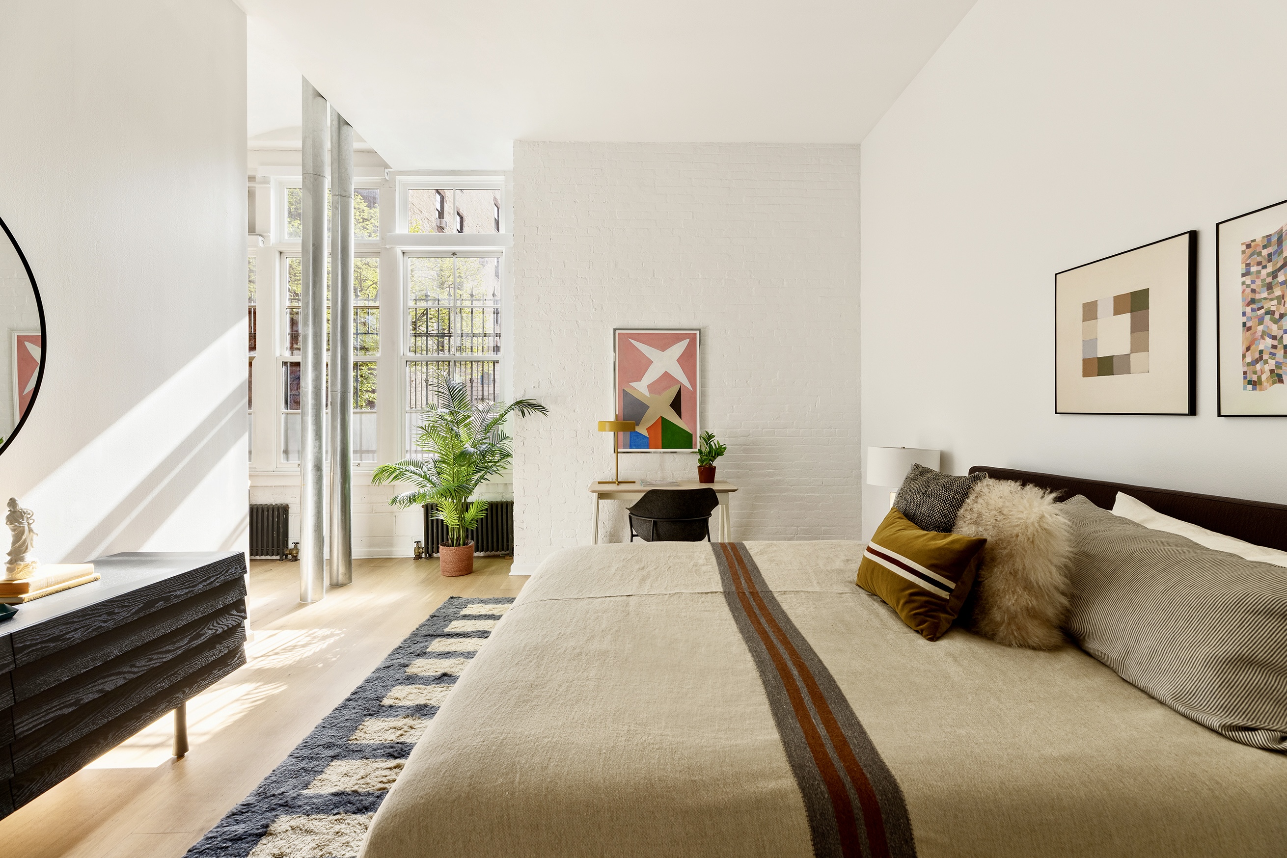720 Greenwich Street, Unit 1F New York, NY 10014 - Photo 6 of 16 a bedroom with a bed a couch and potted plant on the dresser