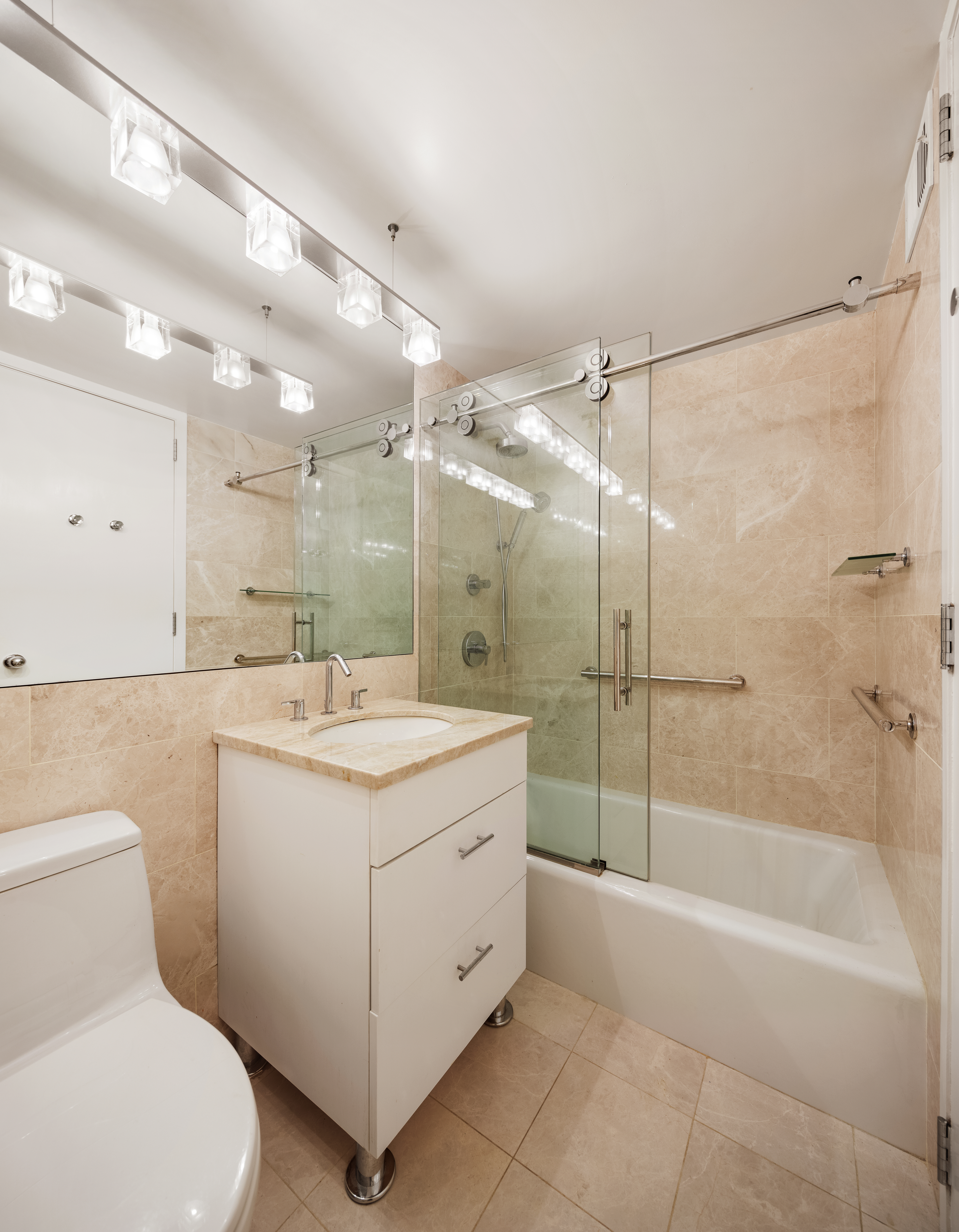 333 East 69th Street, Unit 7F Manhattan, NY 10021 - Photo 7 of 12 a bathroom with a sink toilet and shower