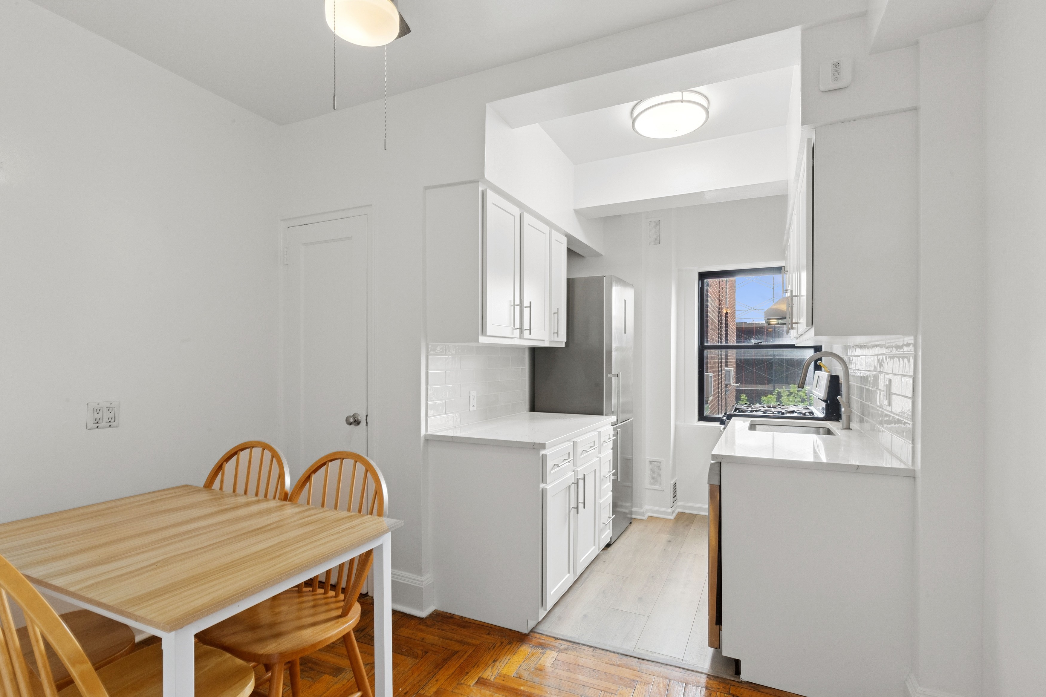 55 Park Terrace East, Unit B74 Manhattan, NY 10034 - Photo 8 of 26 a kitchen with stainless steel appliances granite countertop a stove top oven a sink and white cabinets
