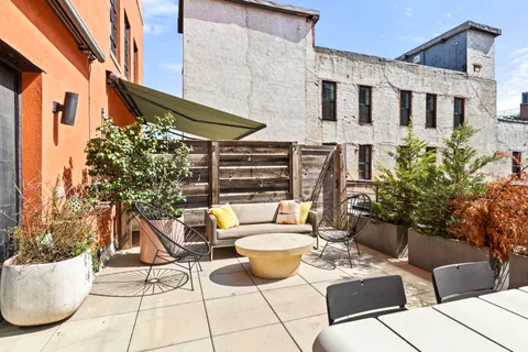 a view of a patio with couches table and chairs and potted plants
