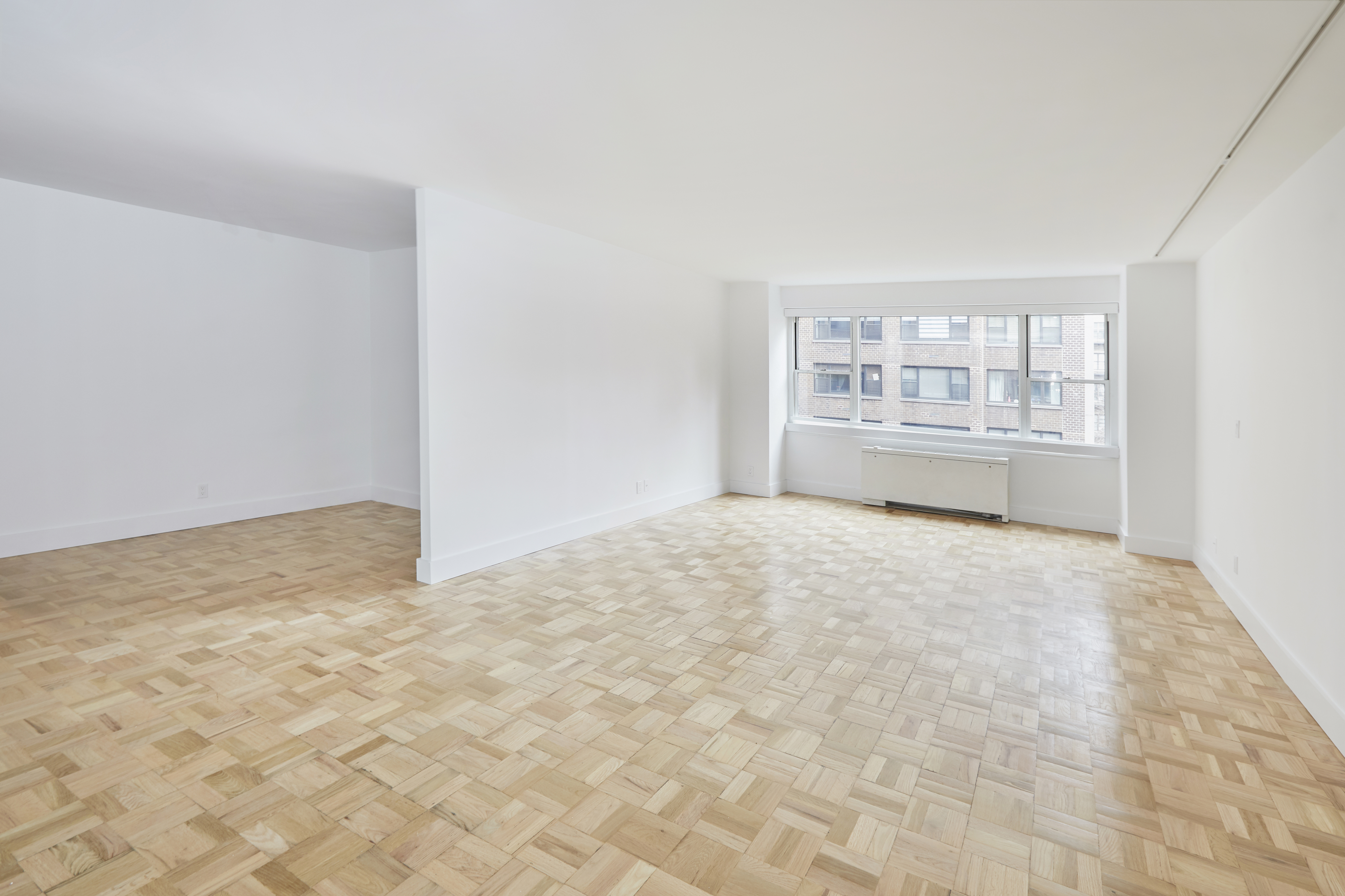 340 East 64th Street, Unit 5B Manhattan, NY 10065 - Photo 7 of 19 a view of empty room with wooden floor and fan