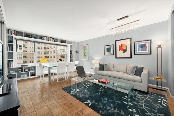 a living room with furniture and a dining table with garden view