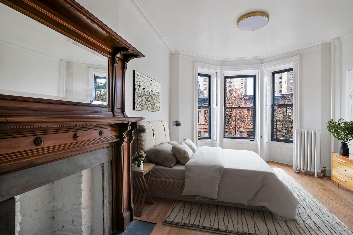 a bedroom with a bed painting on wall and a desk