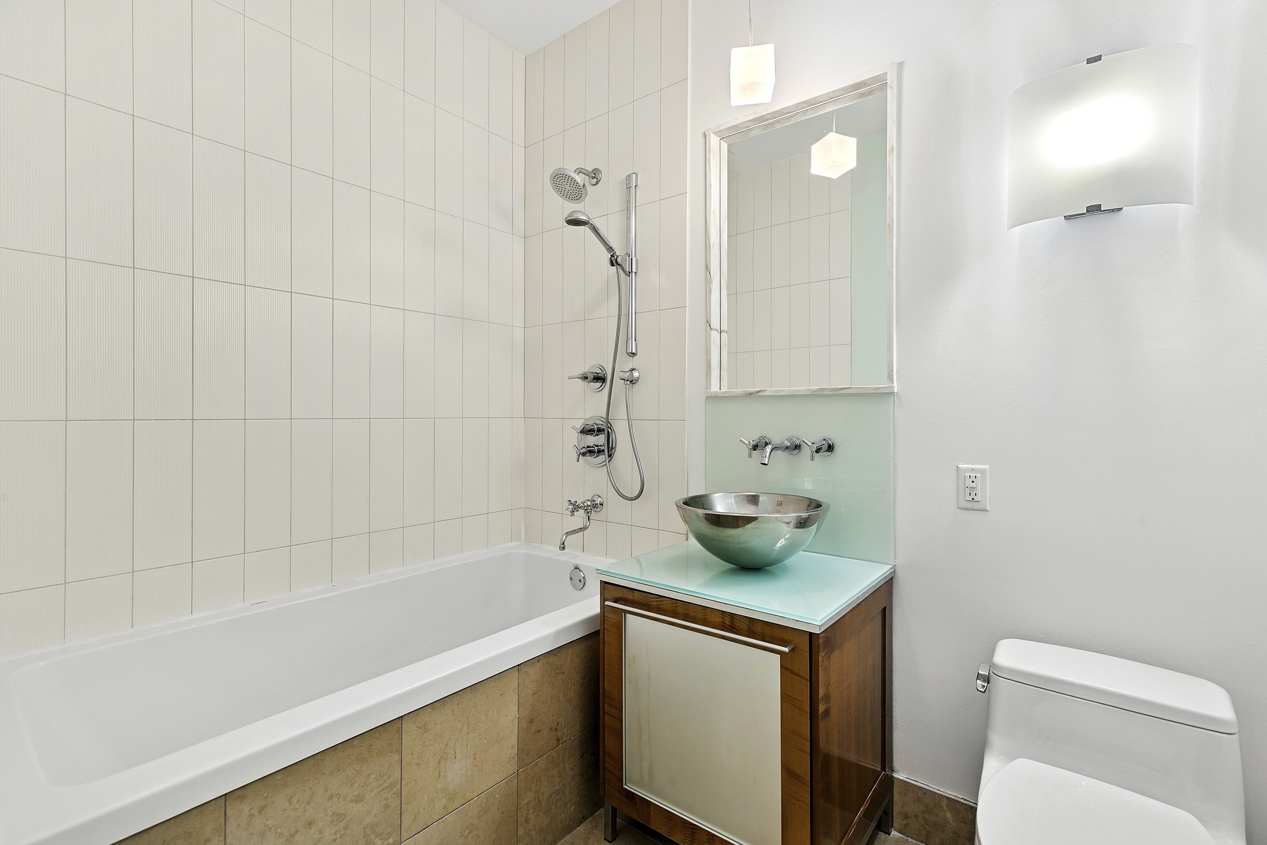 59 John Street, Unit 4H Manhattan, NY 10038 - Photo 10 of 19 a bathroom with a sink a toilet and shower