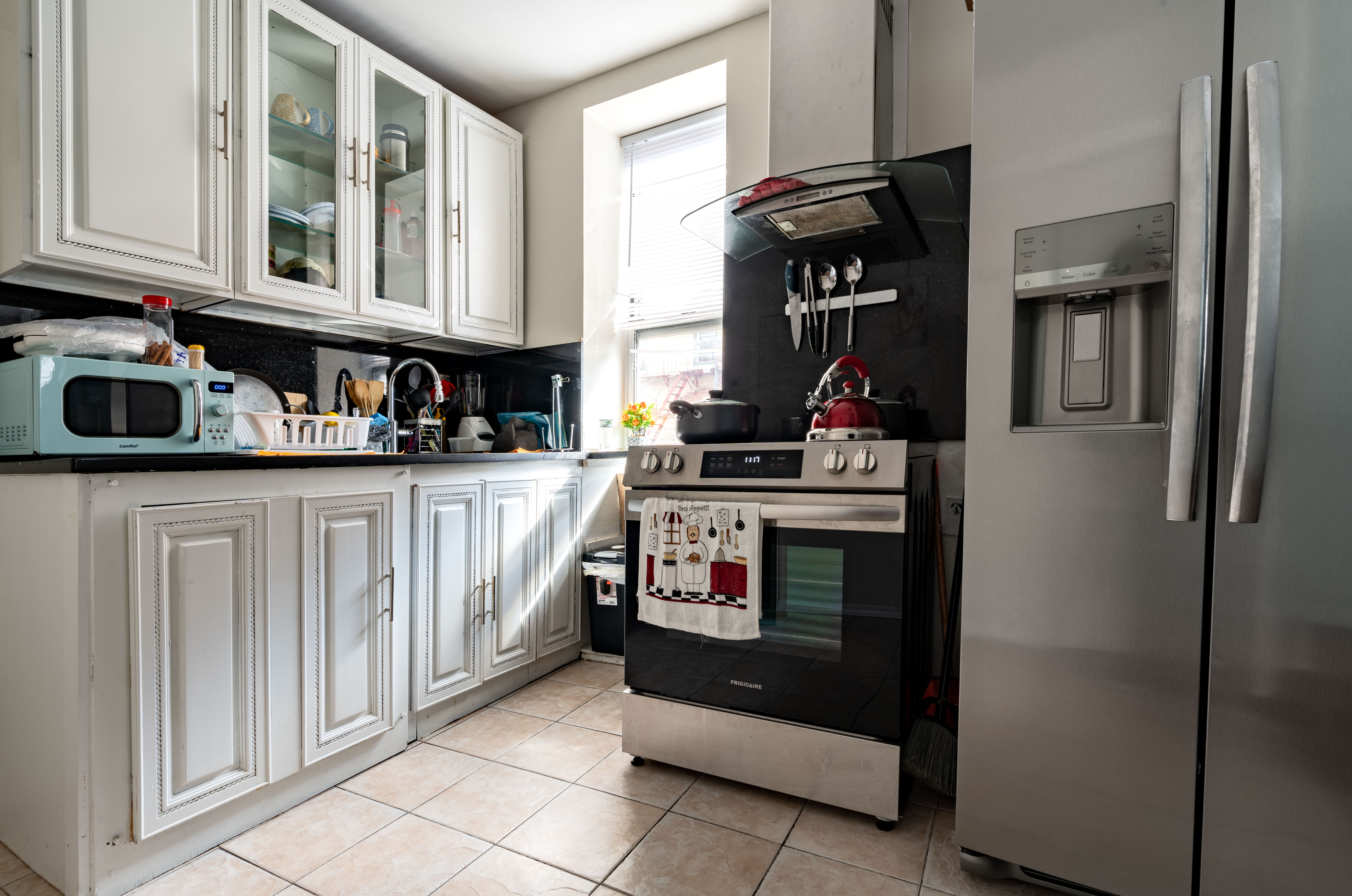 936 Seneca Avenue Queens, NY 11385 - Photo 6 of 12 a kitchen with stainless steel appliances granite countertop a stove and a refrigerator