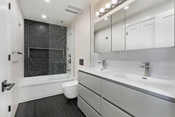 a bathroom with a sink a toilet and shower