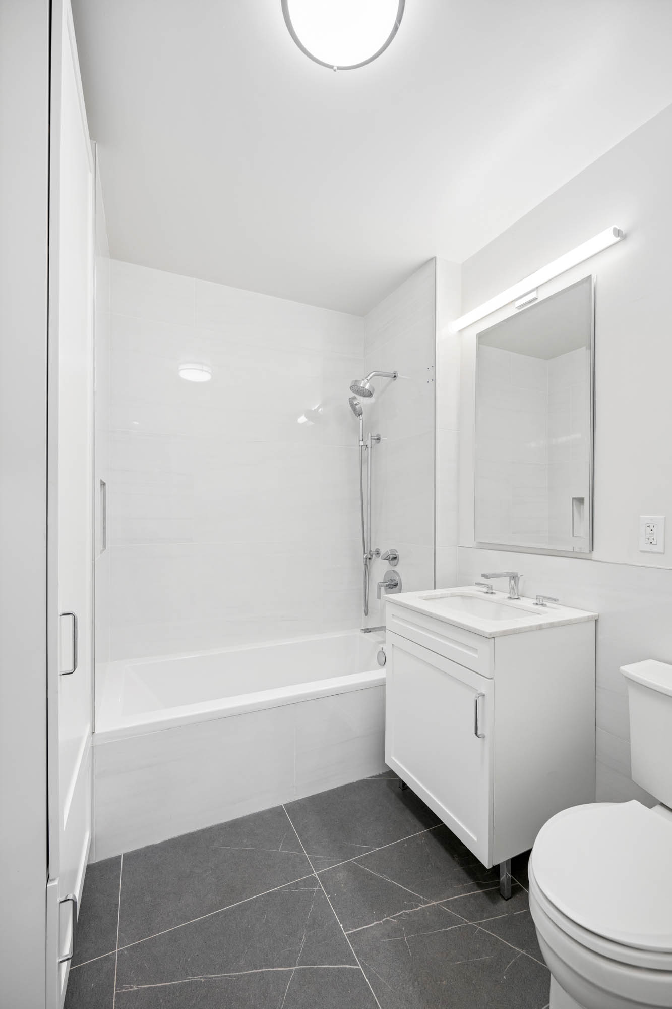 2109 Broadway, Unit 1192 Manhattan, NY 10023 - Photo 5 of 7 a bathroom with a sink a toilet and a mirror