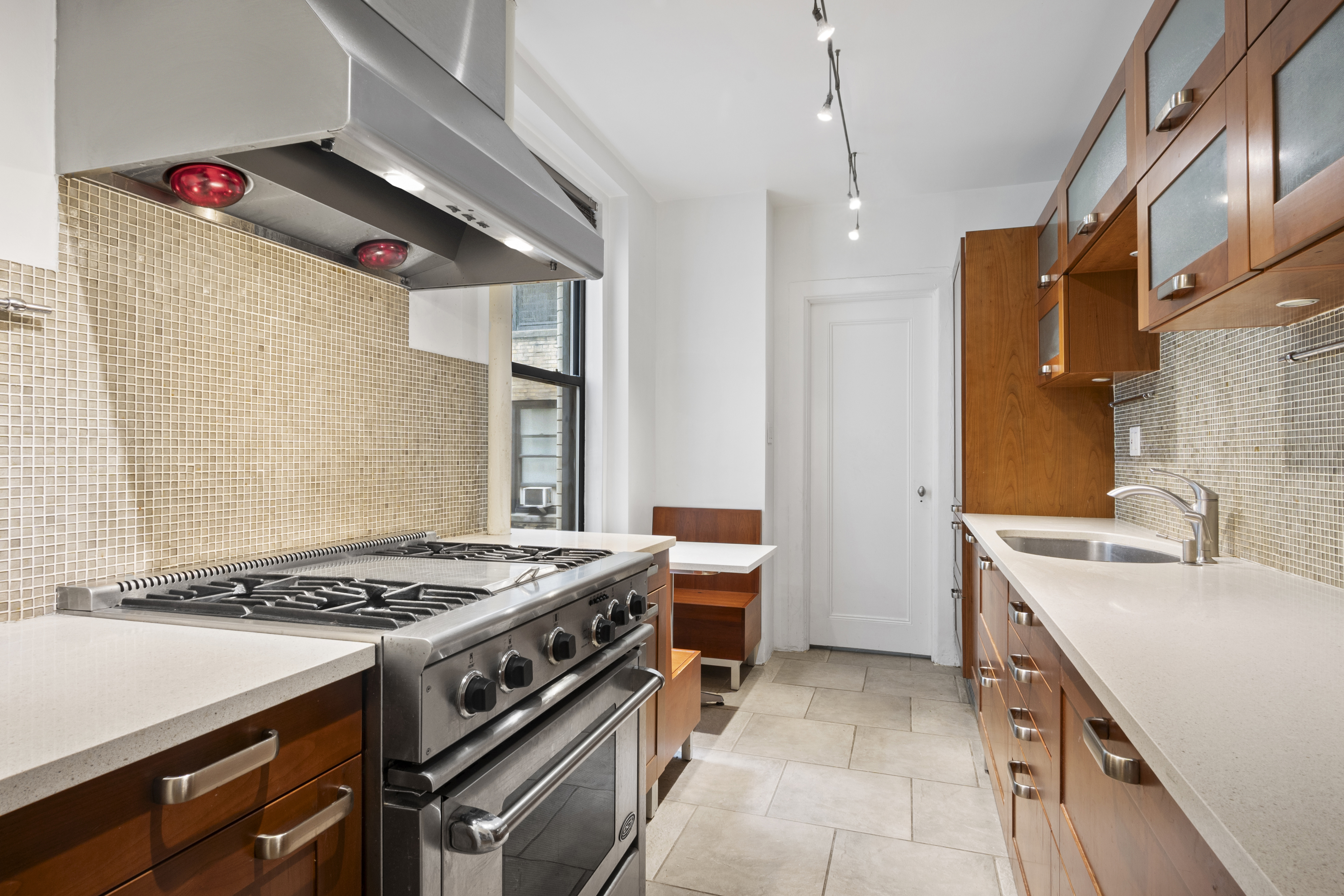 146 East 49th Street, Unit 6CD Manhattan, NY 10017 - Photo 8 of 12 a kitchen that has a sink and a stove