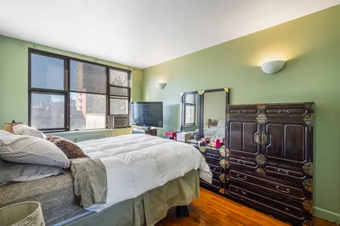 a bedroom with a bed next to a window