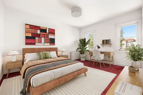 a bedroom with a large bed a potted plant and a couch