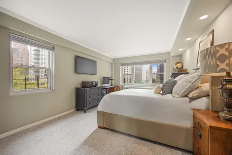 a bedroom with a large bed and a tv on dresser