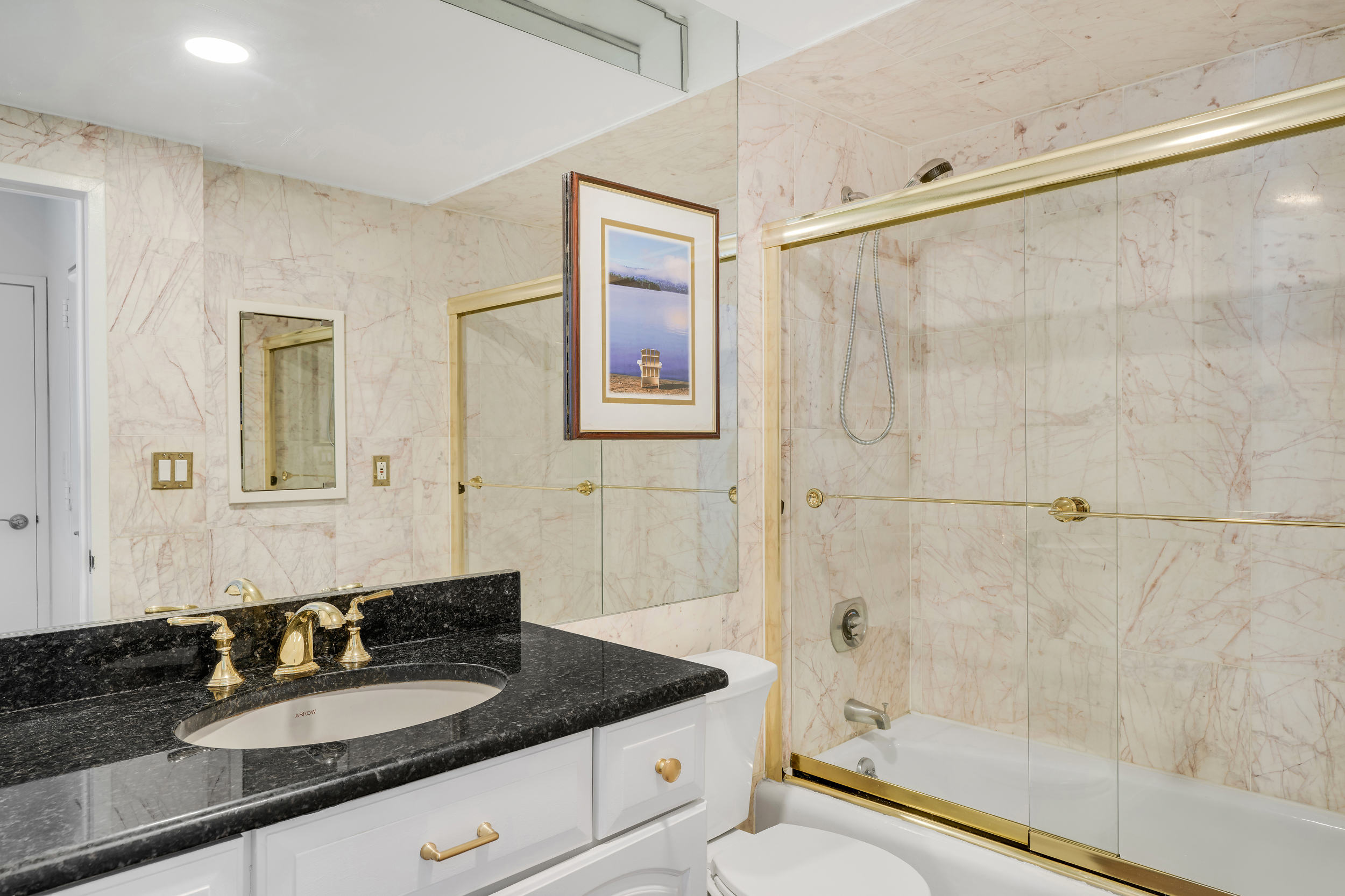 400 East 70th Street, Unit 2402 Manhattan, NY 10021 - Photo 9 of 18 a bath room with a granite countertop sink mirror and shower