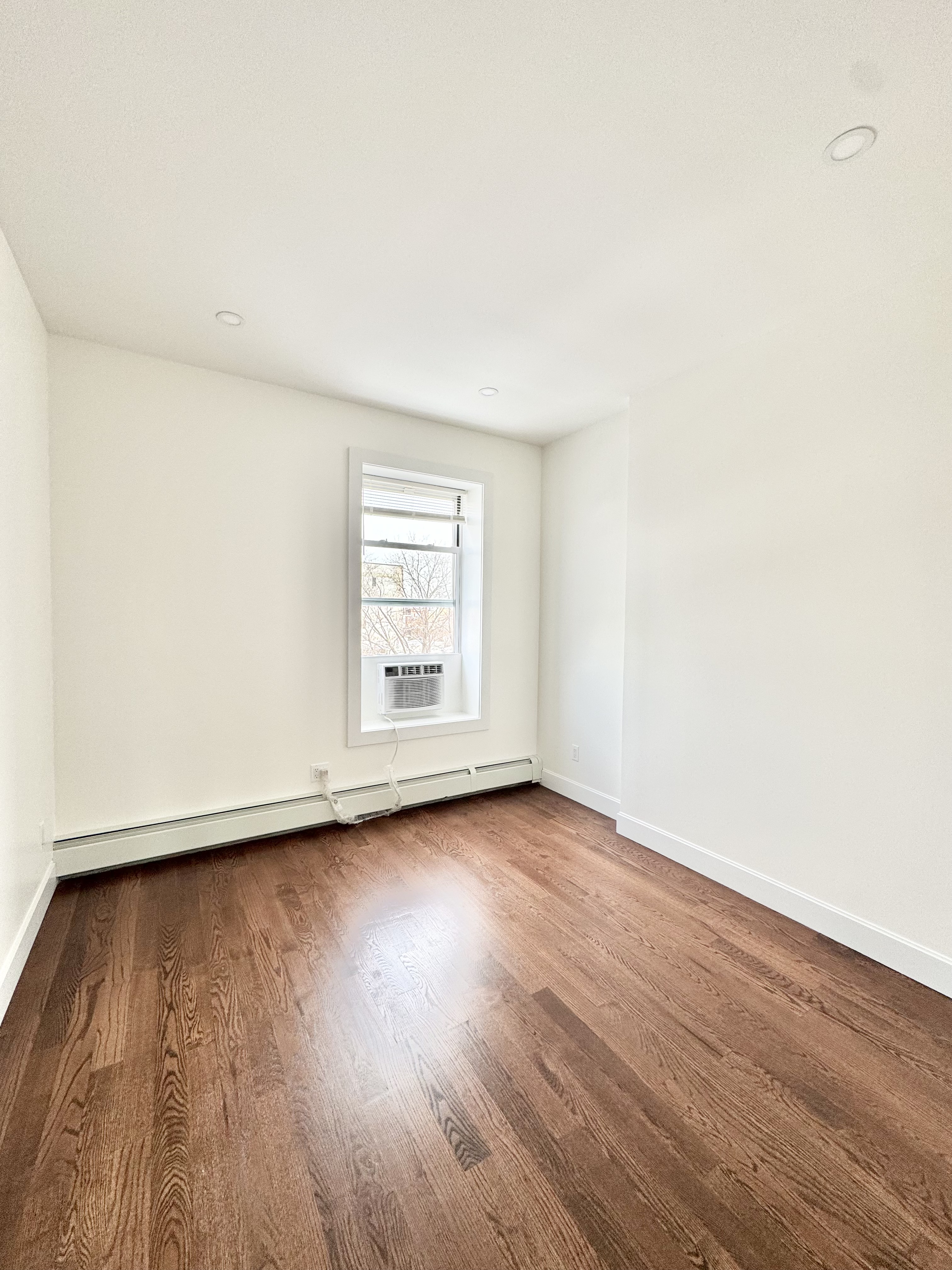 383 Myrtle Avenue, Unit 3 Brooklyn, NY 11205 - Photo 14 of 21 an empty room with wooden floor and windows