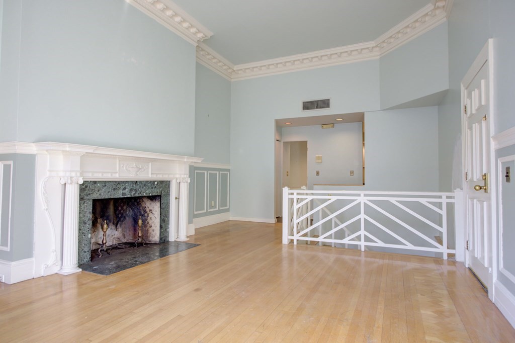 327 Commonwealth Avenue Boston, MA 02115 - Photo 15 of 26 a view of an empty room with wooden floor fireplace and a window