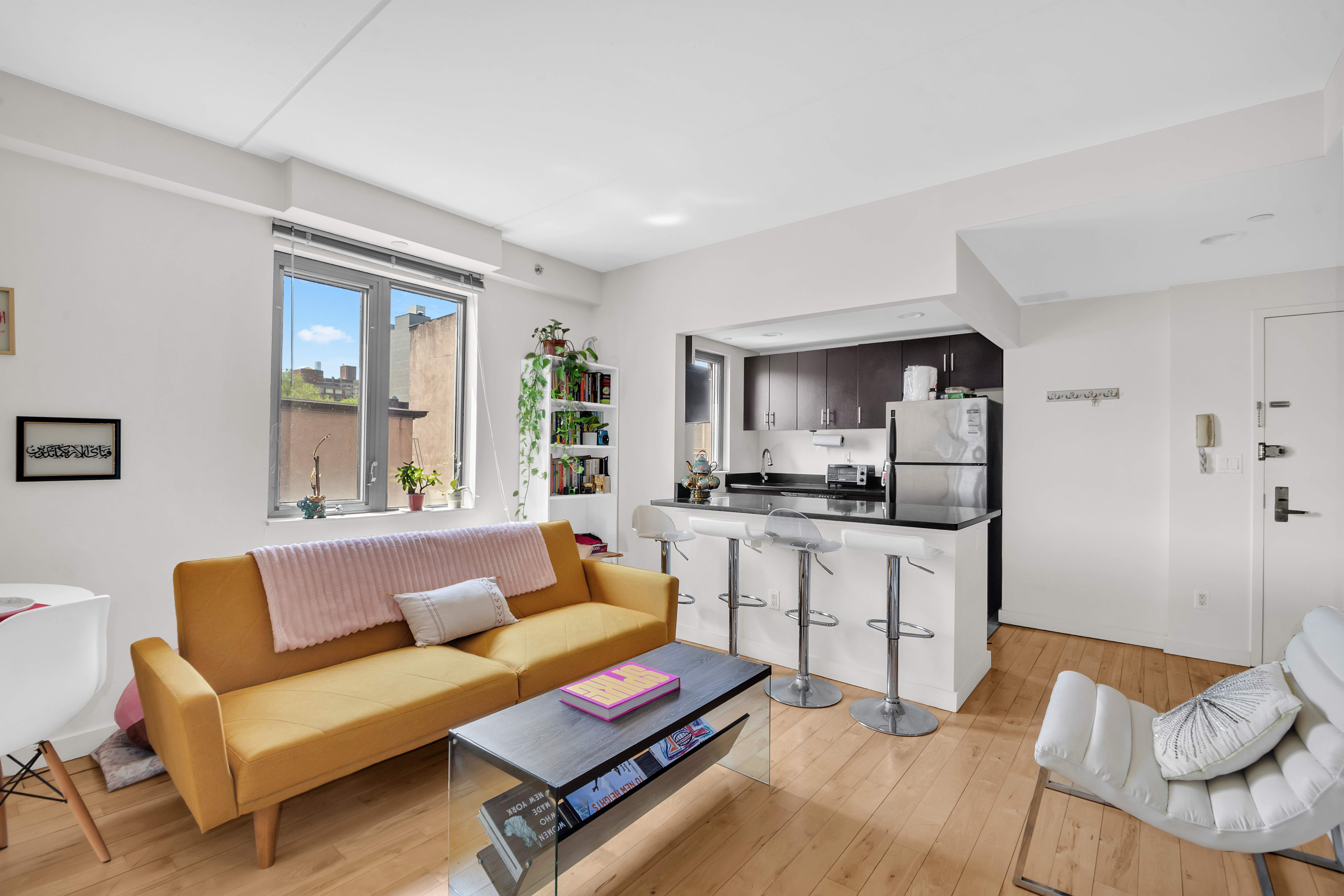 1810 3rd Avenue, Unit A7D Manhattan, NY 10029 - Photo 1 of 13 a living room with furniture a rug and kitchen view