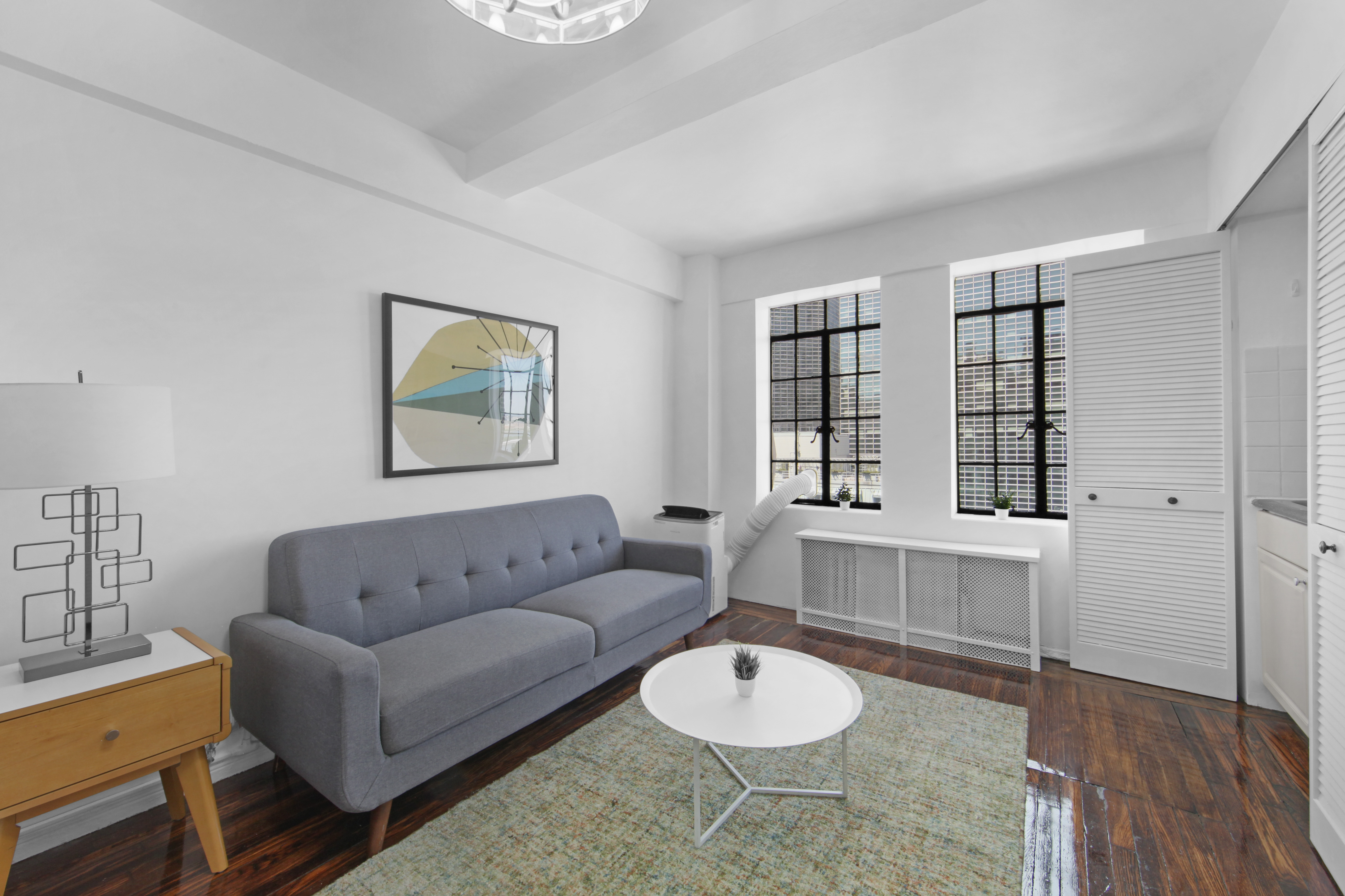 45 Tudor City Place, Unit 1902 Manhattan, NY 10017 - Photo 2 of 14 a living room with furniture and wooden floor