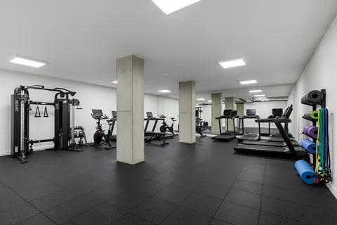 a view of a room with gym equipment and large mirror