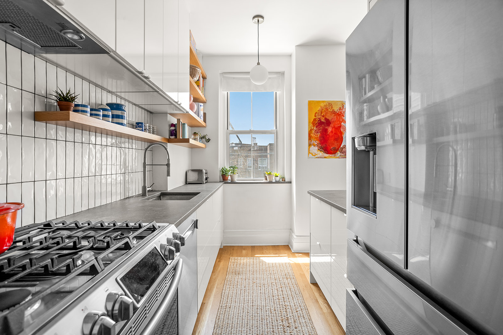 35-14 77th Street, Unit 52 Queens, NY 11372 - Photo 3 of 11 a kitchen with stainless steel appliances granite countertop a stove and a refrigerator