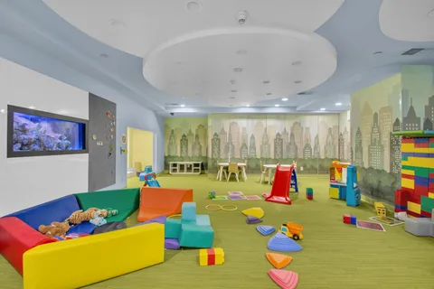 a playing room with toys and a dining table with chairs