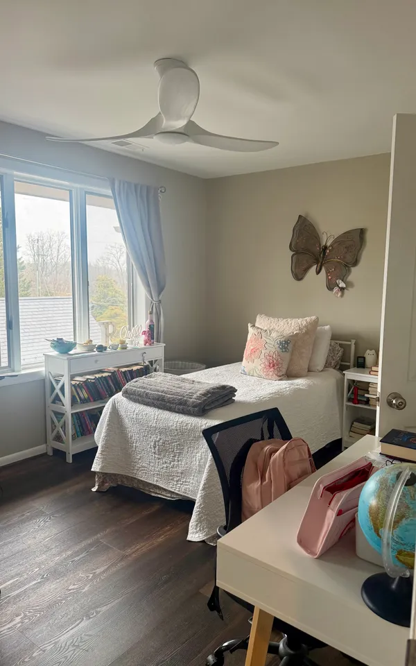 a bedroom with a bed and large windows