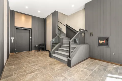 a view of an empty room with stairs and a window