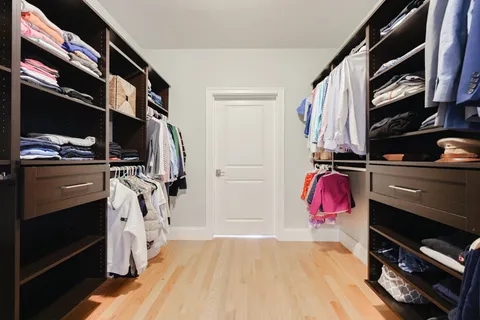a view of walk in closet with clothes and shoes
