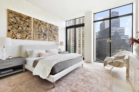 a bedroom with a bed couch and window