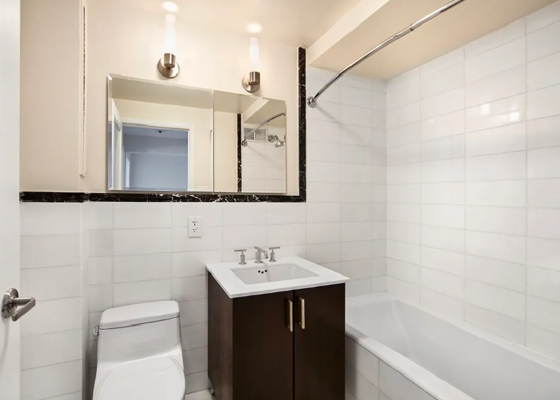 56 7th Avenue, Unit 19H Manhattan, NY 10011 - Photo 7 of 12 a bathroom with a sink a toilet and shower