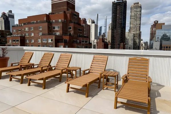 a roof deck with outdoor seating and city view