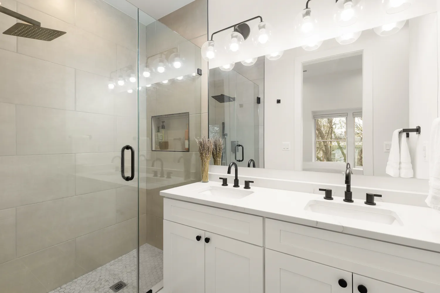a bathroom with a double vanity sink mirror and shower