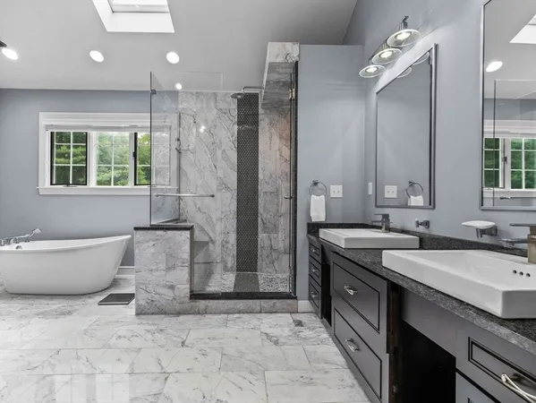 a spacious bathroom with a granite countertop sink a toilet a mirror and shower