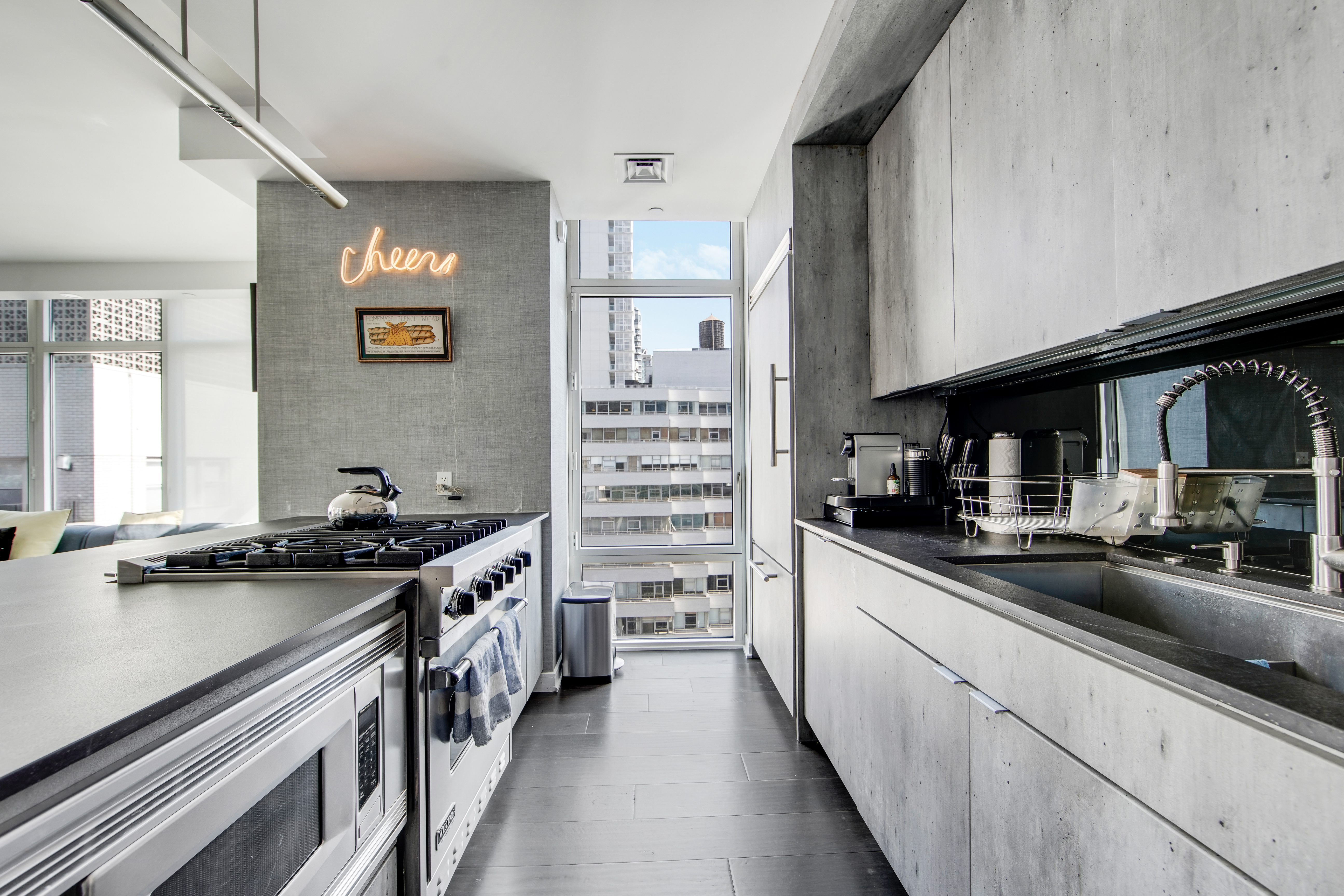 207 East 57th Street, Unit 20A Manhattan, NY 10022 - Photo 6 of 18 a kitchen with stainless steel appliances a sink stove and cabinets