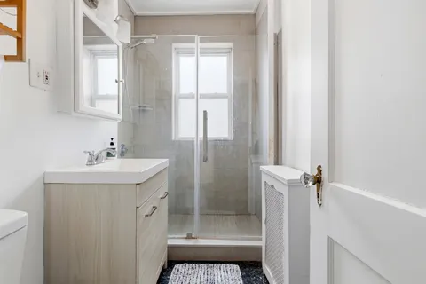 a bathroom with a sink a toilet and shower