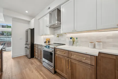 a kitchen with stainless steel appliances granite countertop a sink a stove a refrigerator and cabinets