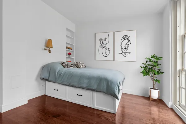 a bedroom with a bed and a potted plant